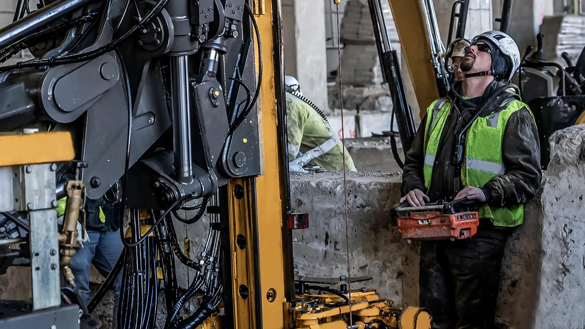 Man using remote control to operate construction equipment on jobsite