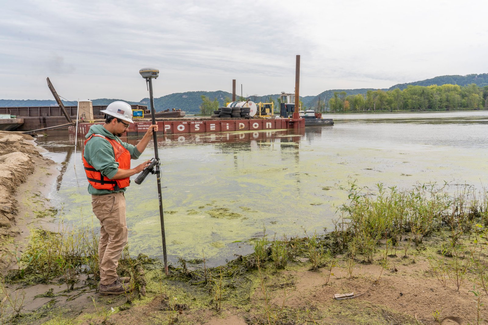 A worker works at the edge of the Upper Mississppi River.