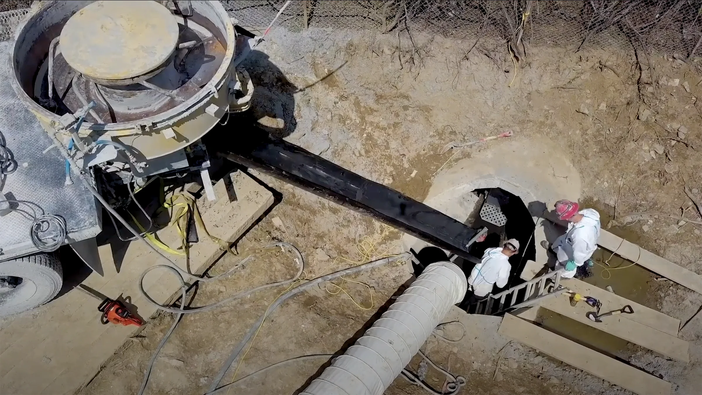 Crew lowers a large diameter liner inside a sewer pipe