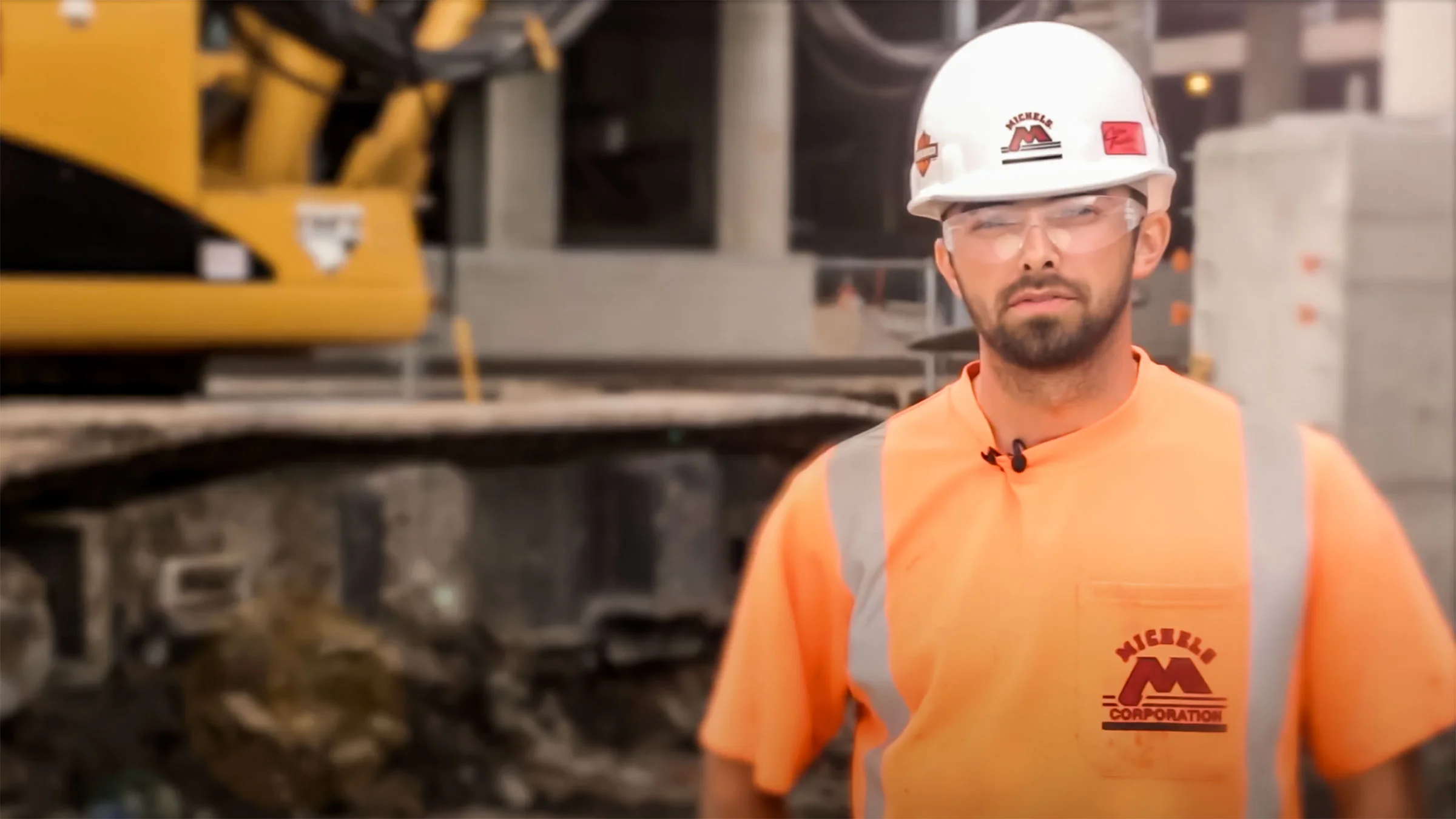 Man standing for a picture in front of an excavator.