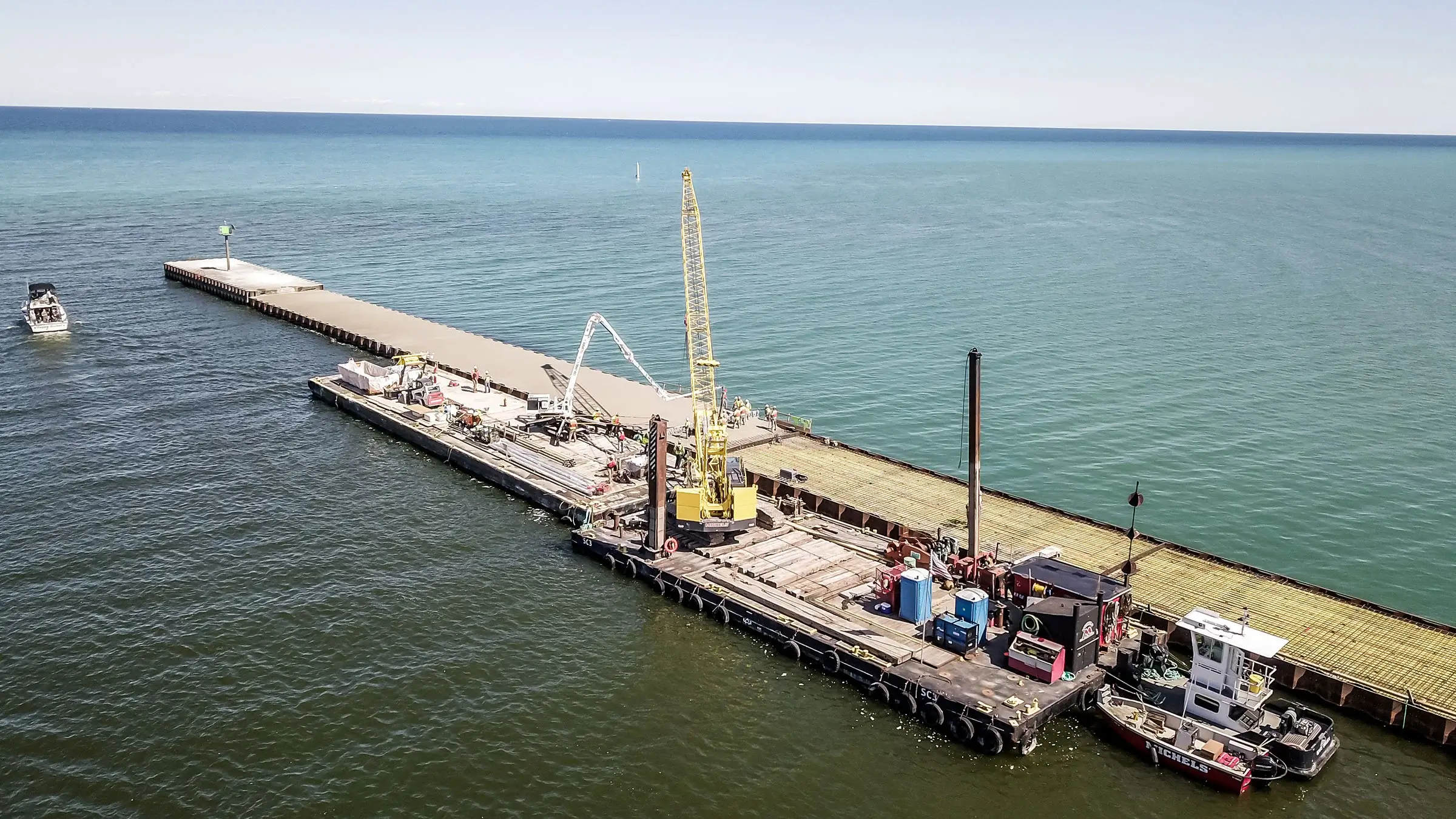Two barges working along a pier on the lake.
