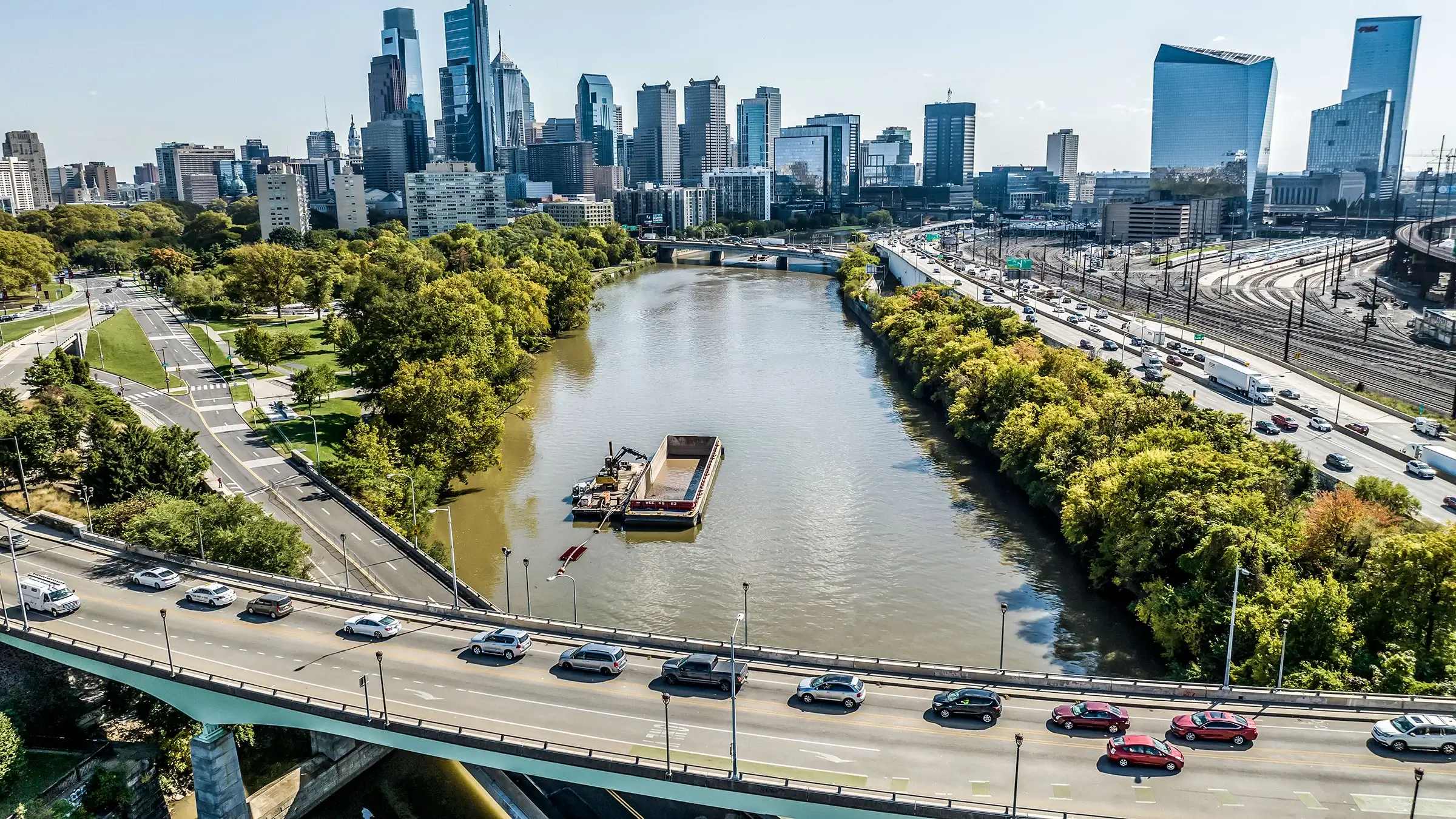Cars on a busy bridge drive over the Schuylkill River